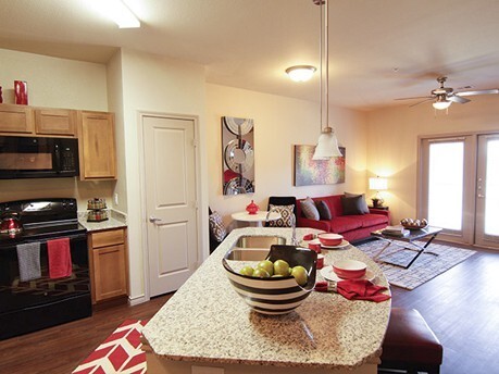 a kitchen and living room area with a stove and refrigerator at The Anatole at City View
