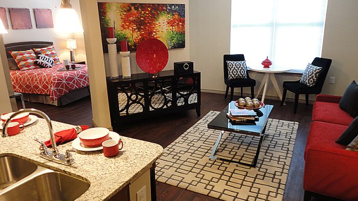a living room with a couch, coffee table, and a kitchen at The Anatole at City View
