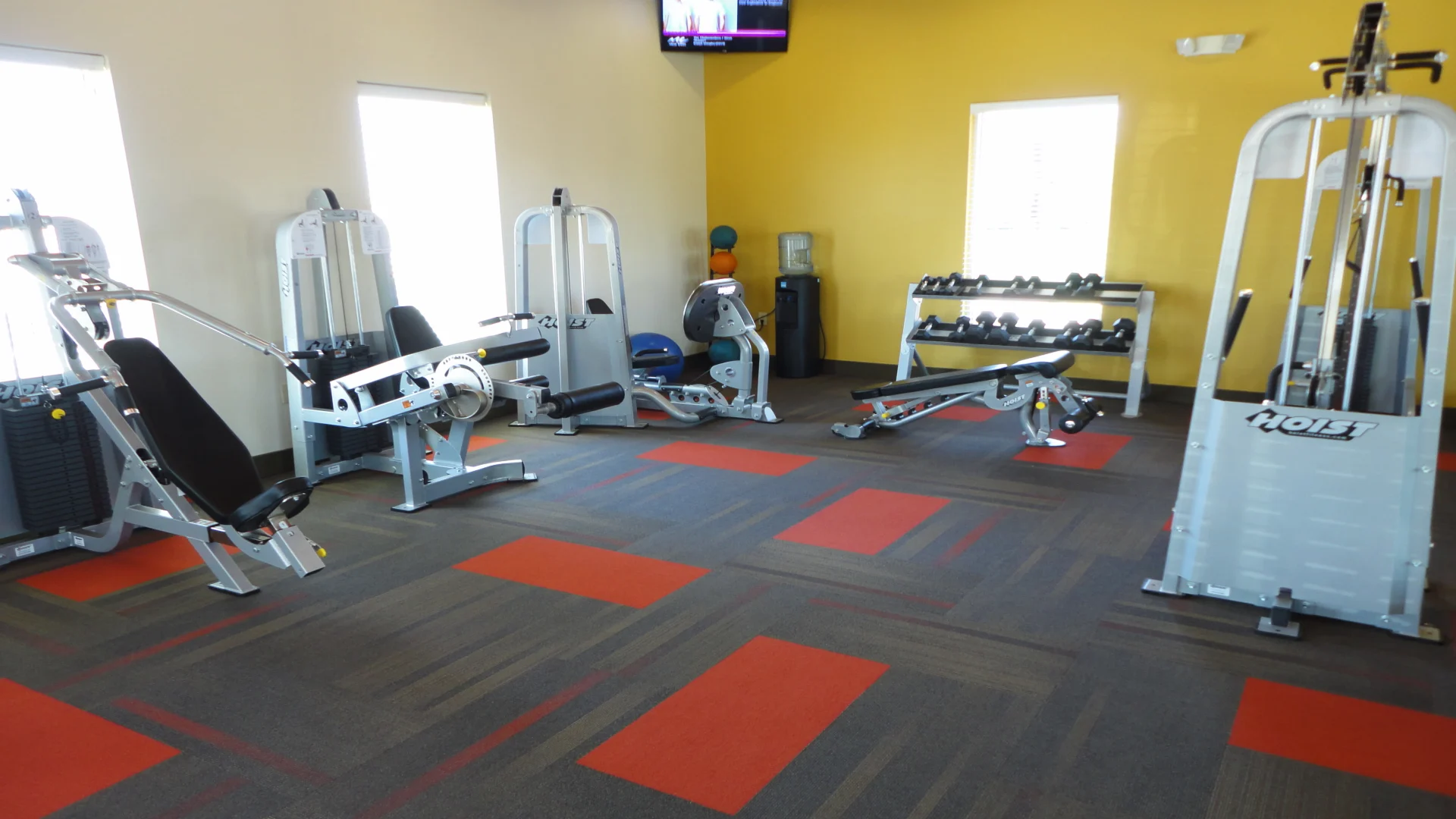 a gym room with equipment and a television at The Anatole at City View