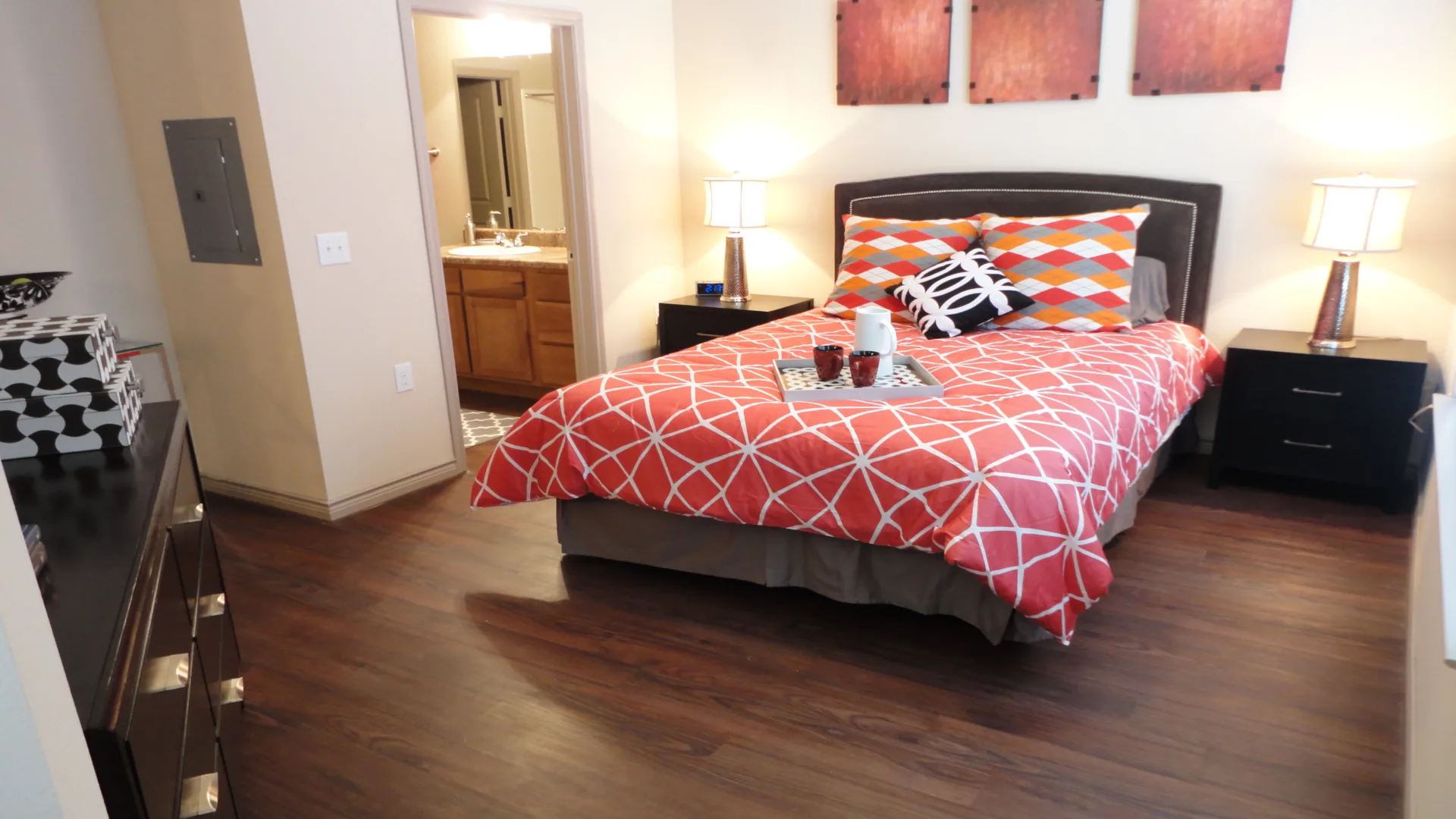 a bedroom with a red and orange bedspread at The Anatole at City View